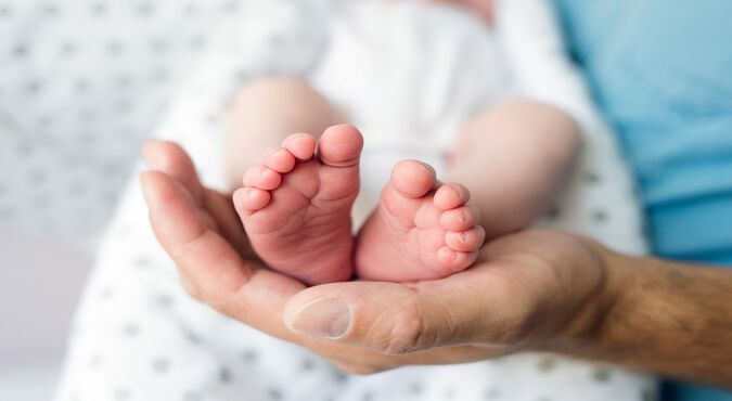 Bebê prestes a pronunciar as primeiras sílabas com babador sorrindo para as cameras