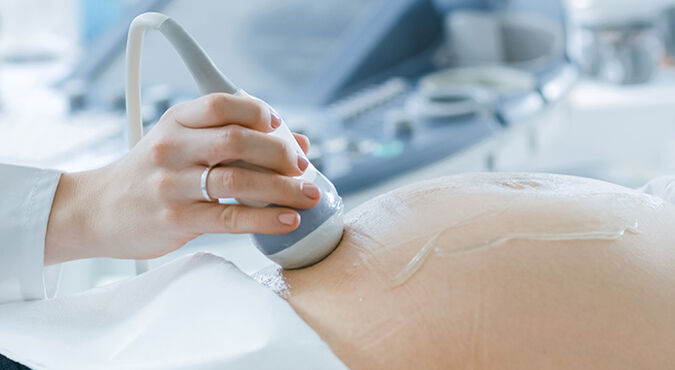 Médico realizando ultrassonografia em gestante