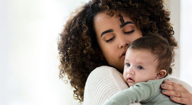 Bebê no colo da mãe em posição para arrotar