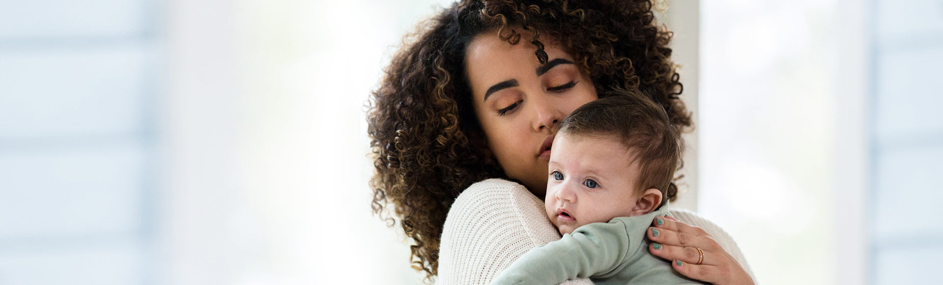 Bebê no colo da mãe em posição para arrotar