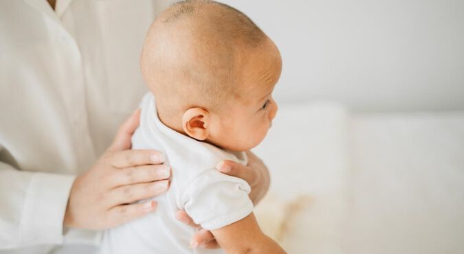 Bebê com soluço sendo amparado pela mãe