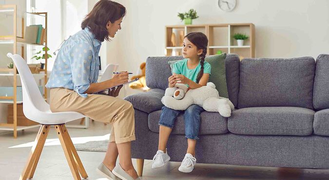 Psicóloga conversando com menina