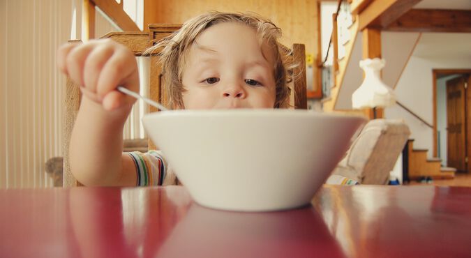 Bebê comendo com a ajuda da mamãe