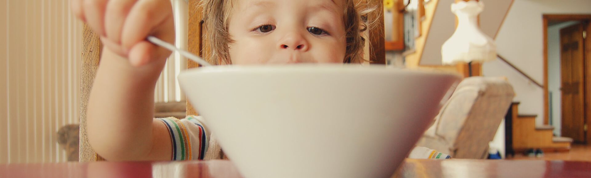Bebê comendo com a ajuda da mamãe
