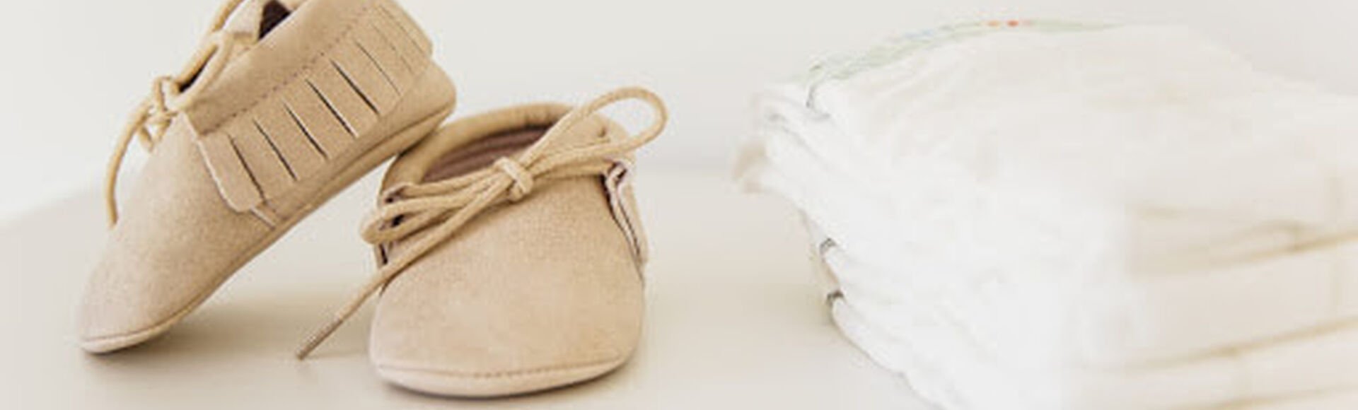 Quantidade e tamanho de fraldas de bebê - Seus Abraços Inspiram os Nossos - Huggies® Brasil Fraldas de bebê ao lado de sapatinhos