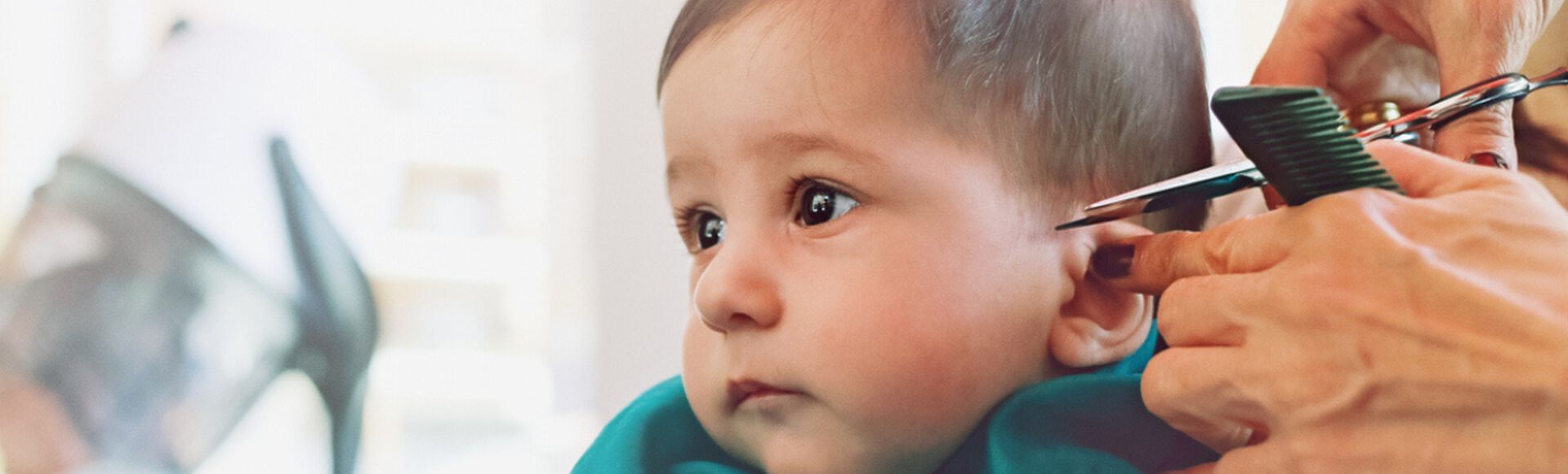 Bebê sentado recebendo corte de cabelo profissional