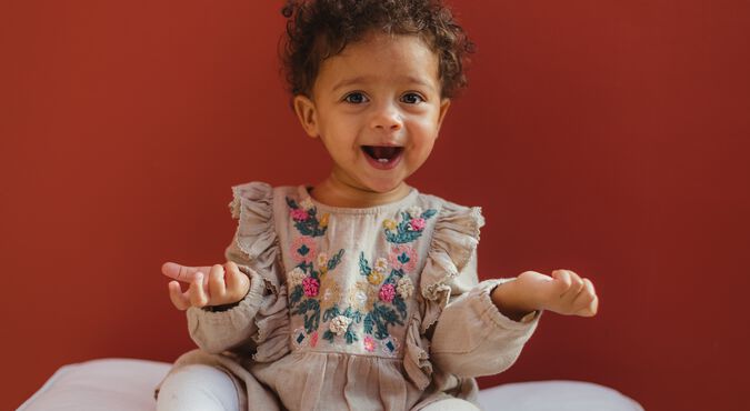 Uma bebê menina coberta com um roupão e uma toalha enrolada na cabeça