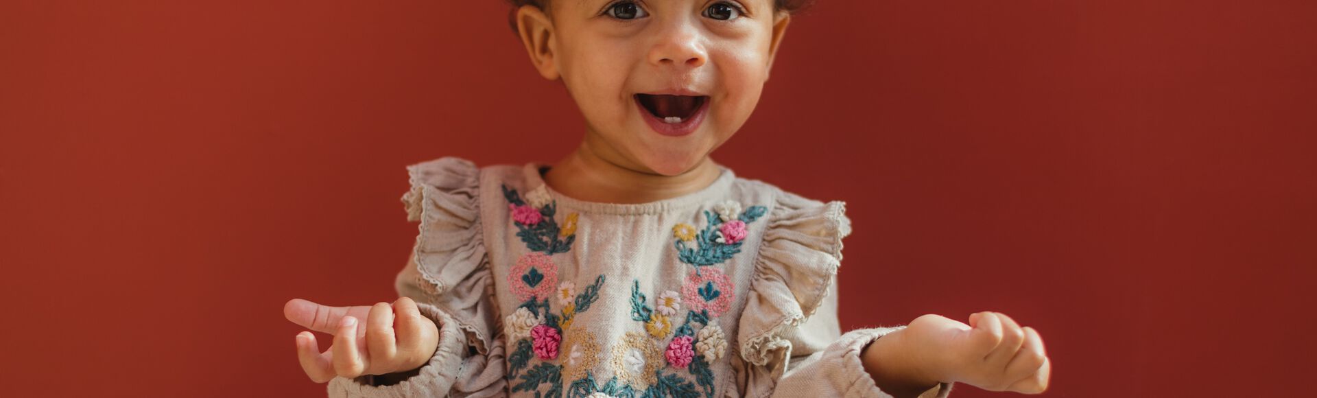 Uma bebê menina coberta com um roupão e uma toalha enrolada na cabeça