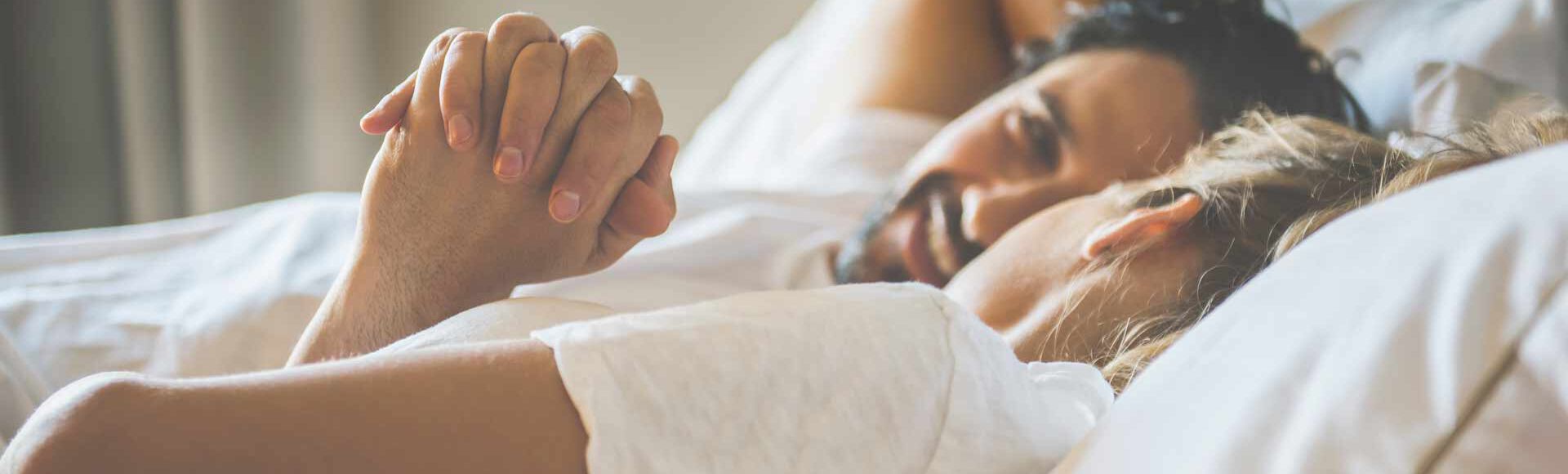 Casal deitado de mãos dadas