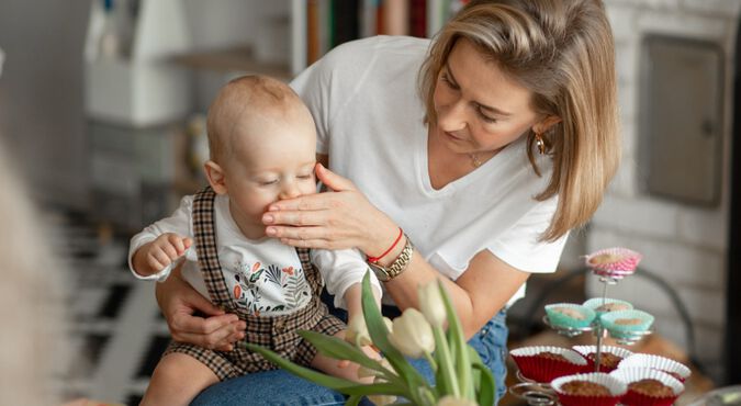 Mae segurando bebe no colo