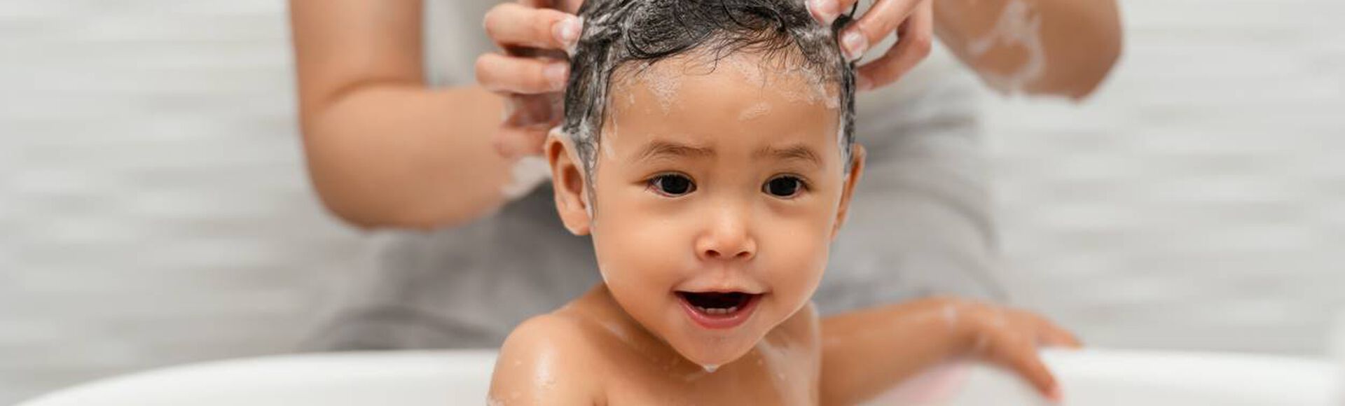 Criança lavando o cabelo com shampoo e condicionador infantil
