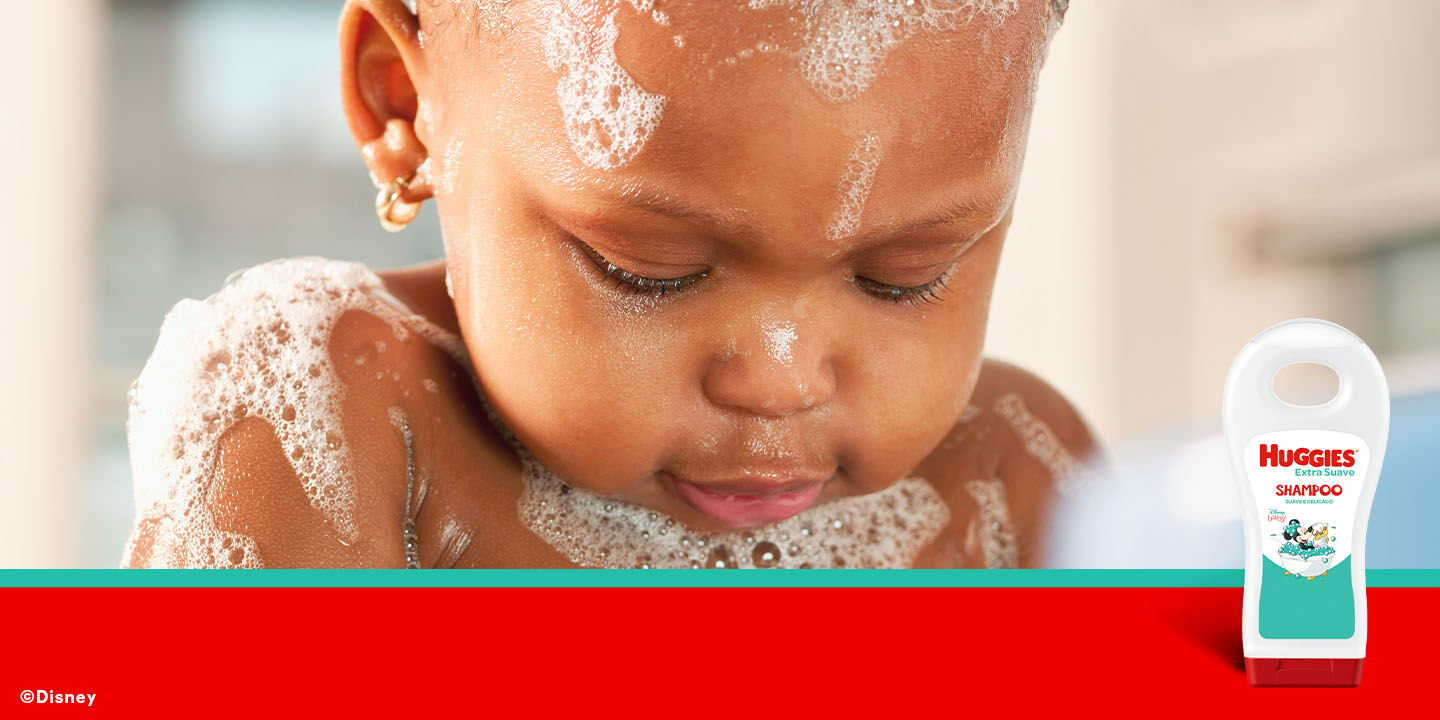 Bebê tomando banho com o shampoo Huggies.