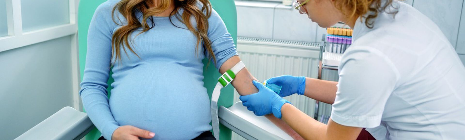 Profissional realizando coleta de sangue de gestante para exames