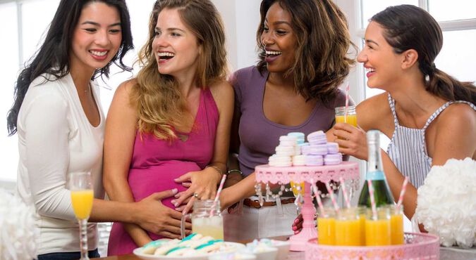 Amigas celebrando um chá de fralda com a grávida no centro.