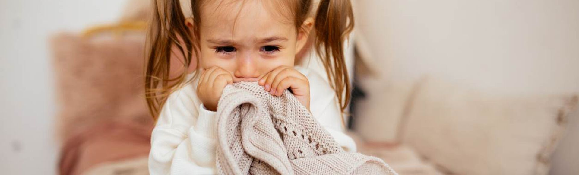 Menina chorando e segurando cobertor