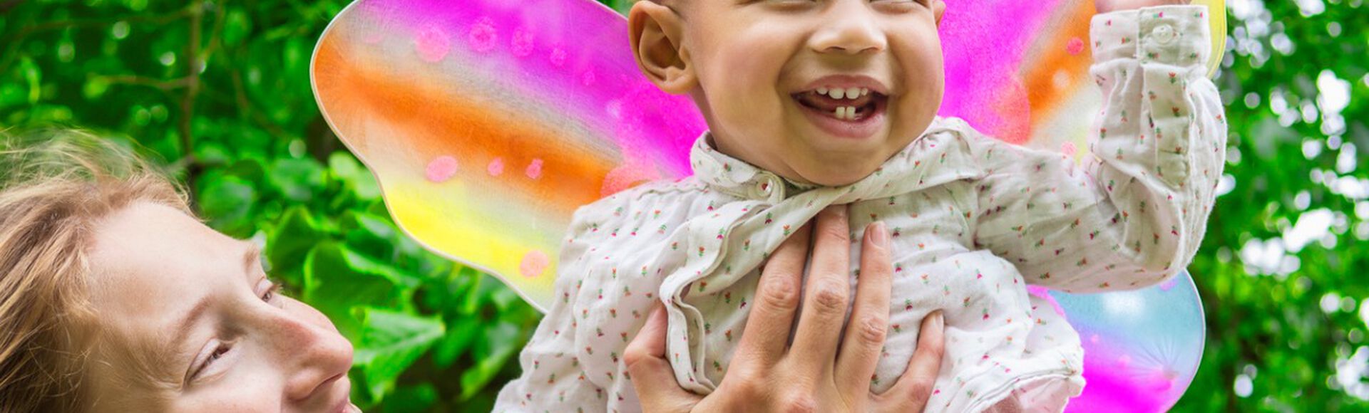Mãe levantando a filha fantasiada em momento de curtição no carnaval