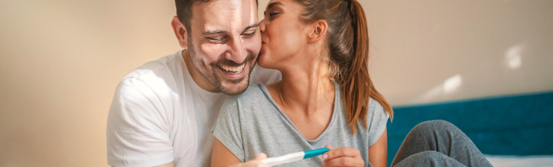 Casal feliz segurando teste de gravidez