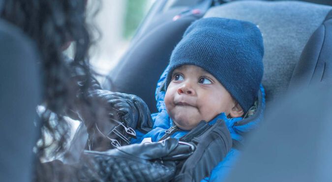 Bebê agasalhado em cadeirinha de carro