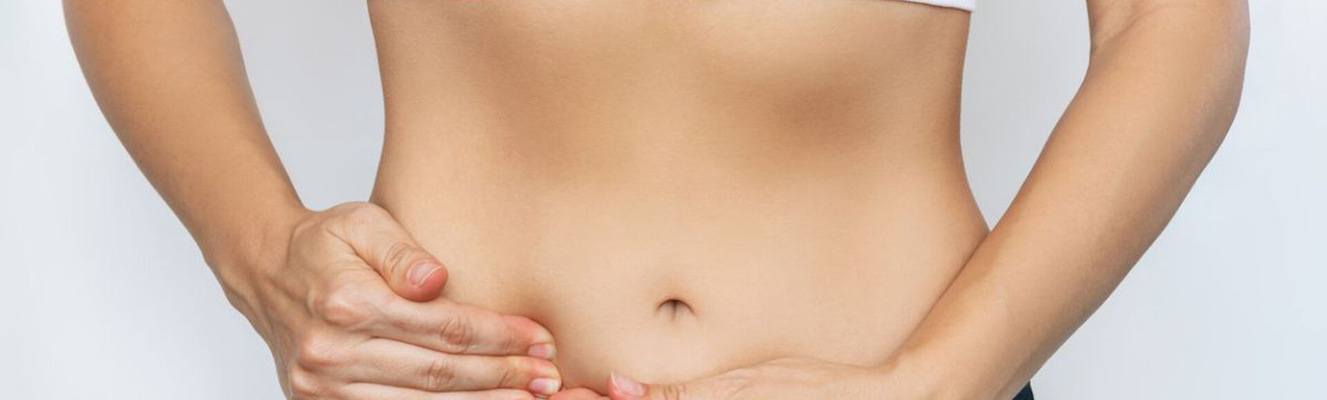 Imagem de mulher apalpando a barriga em sinal de desconforto