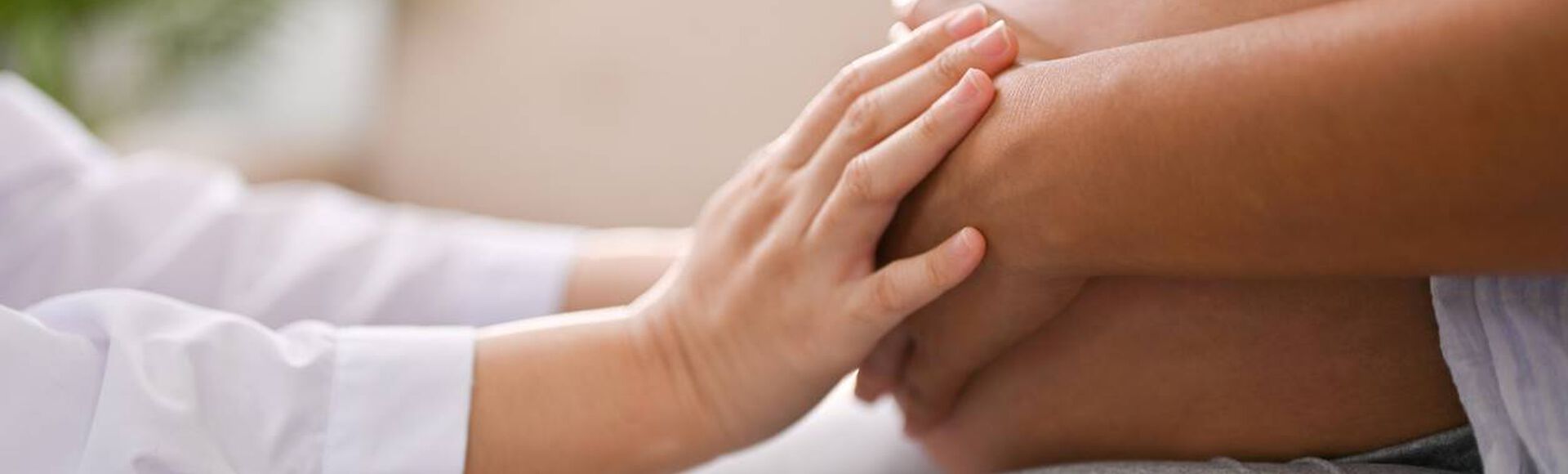 mulher grávida com as mãos de outra pessoa tocando sua barriga
