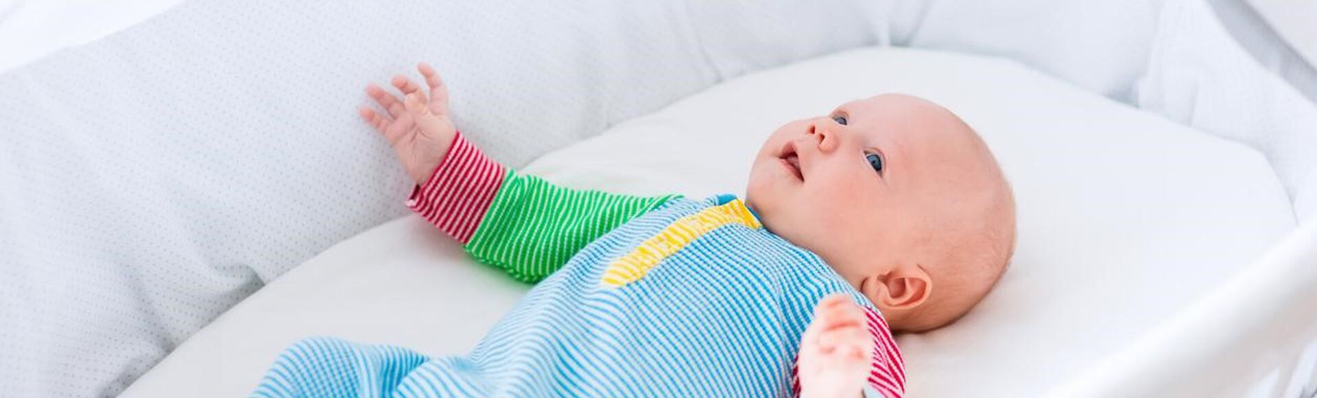 Bebê dormindo em berço moisés