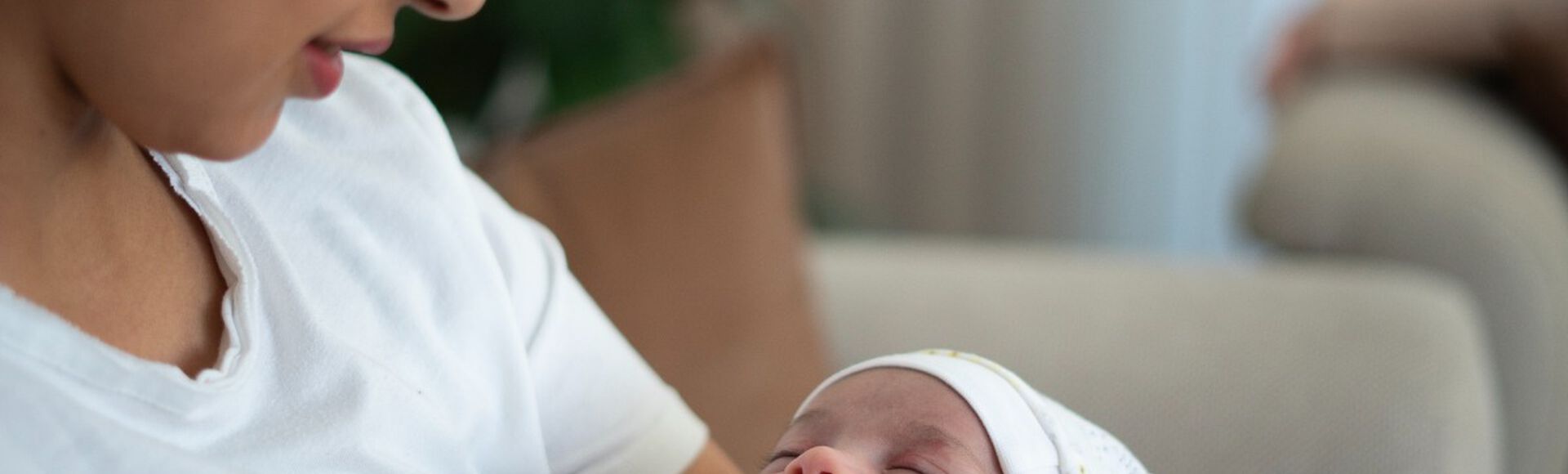 Mãe observando recém-nascido em seu colo