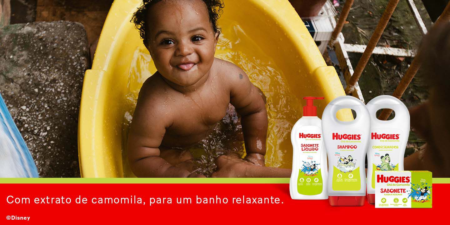 Bebê tomando banho com o shampoo Huggies.