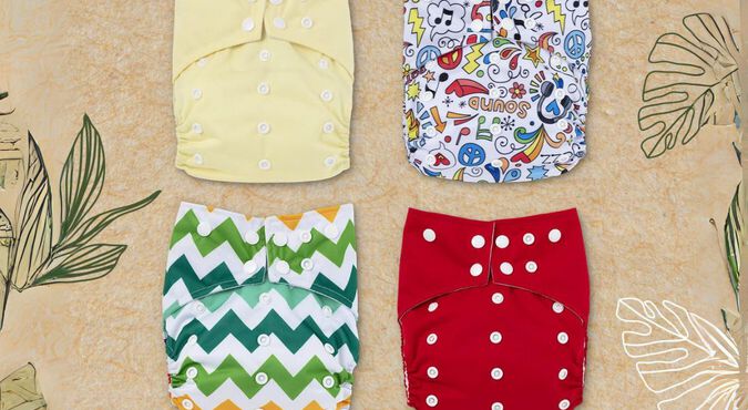 Quatro fraldas Huggies eco protect com estampas sortidas dispostas sobre fundo bege floral