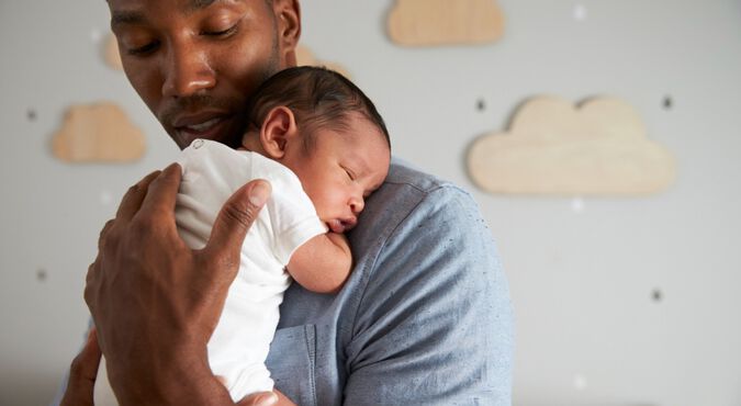 Pai com bebê pequeno no colo