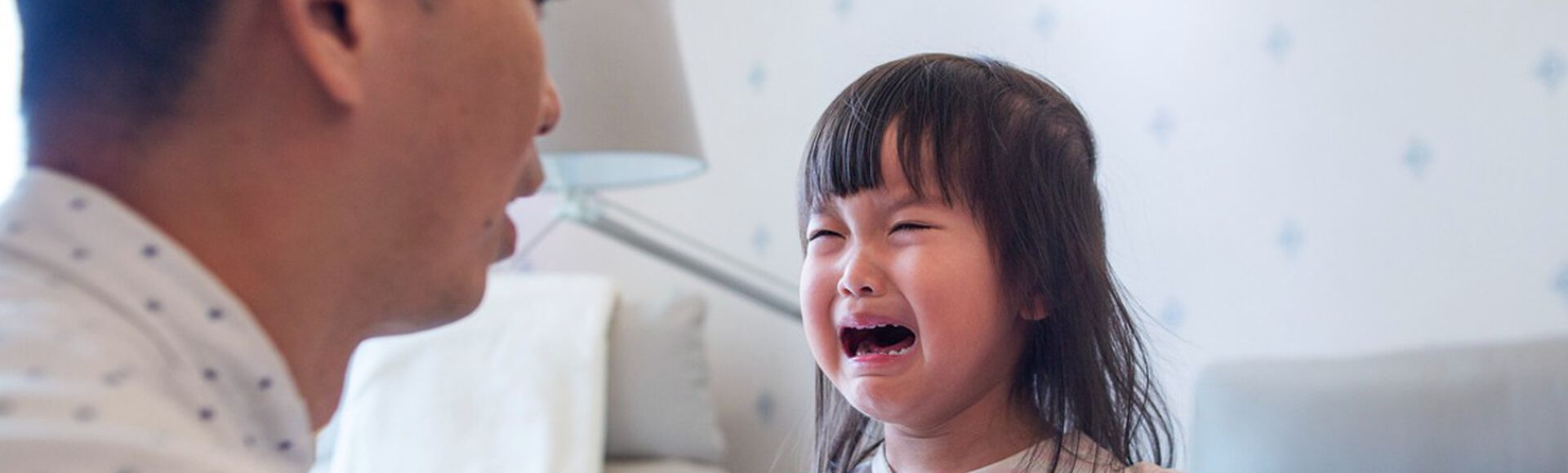 Criança chorando em frente ao pai