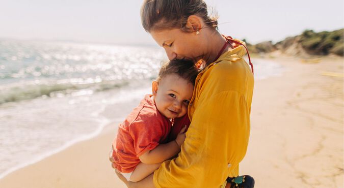 Bebê no colo da mãe na praia