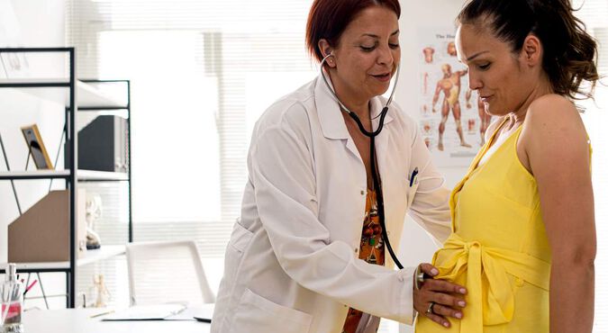 Médica examinando mulher grávida