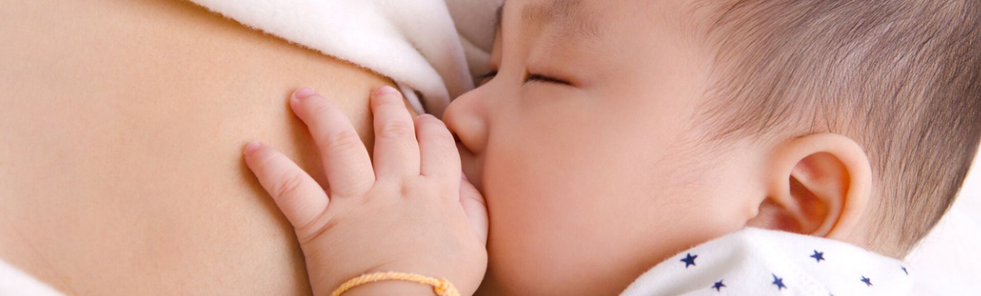 Imagem de um bebê mamando no peito da mãe