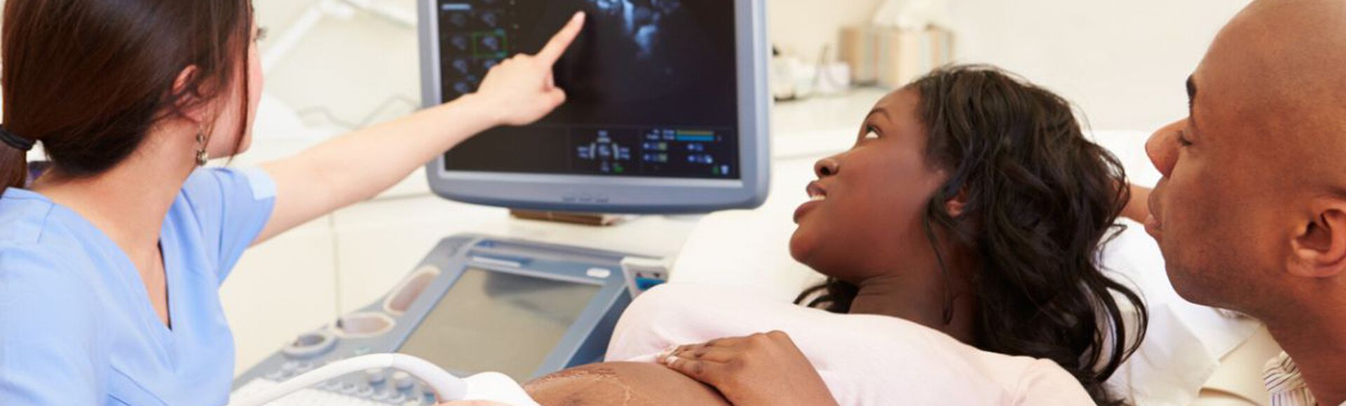 Mulher negra realizando ultrassom em companhia do parceiro