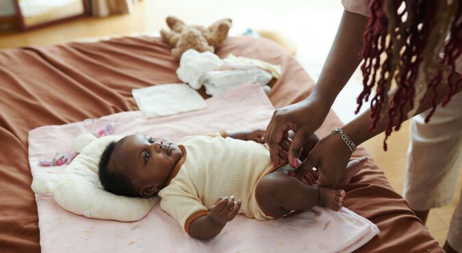 Mãe trocando a fralda de bebê