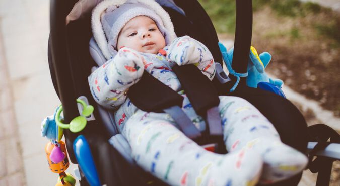 Bebê vestido com roupas de frio em carrinho