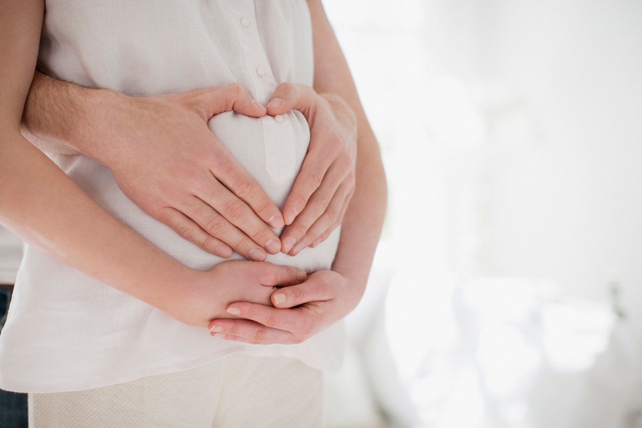 Decoração chá revelação com casal fazendo um coração na barriga