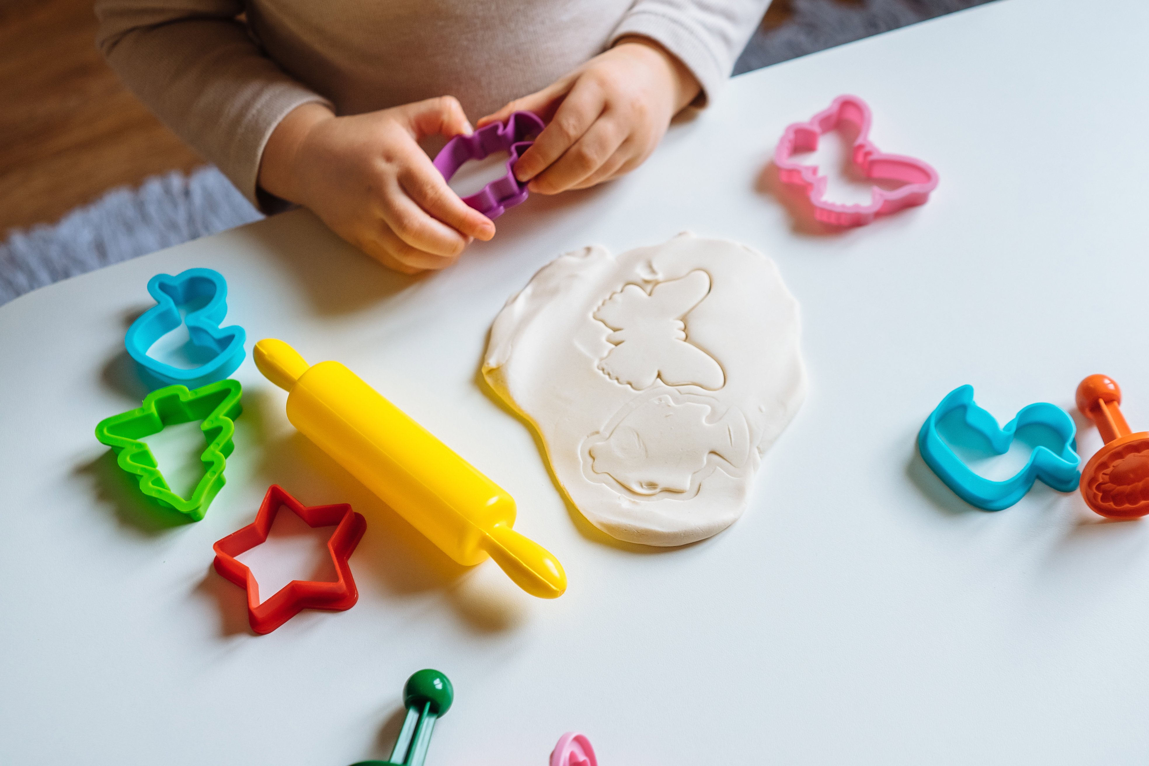 Menina brincando com massinha em uma atividade importante para a educação infantil