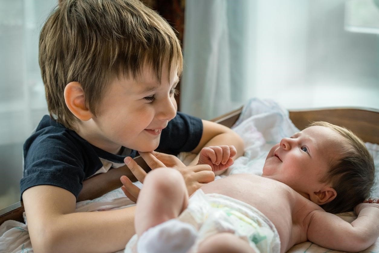 Irmão mais velho olhando admirado para bebê