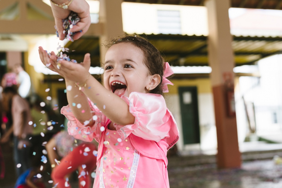 Menina soprando confetes no Carnaval