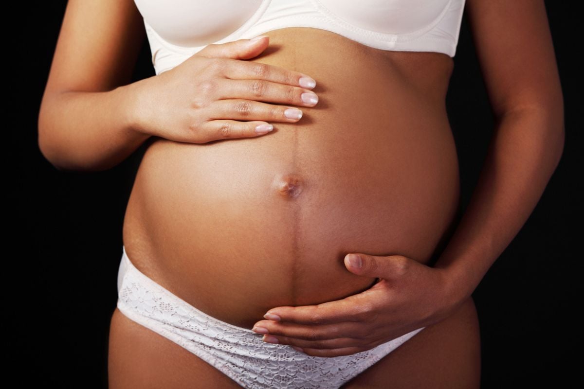 Gestante com as mãos na barriga